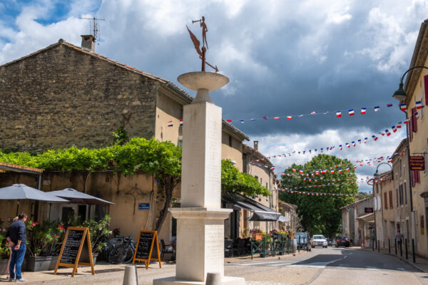 Rue principale d'Entrechaux avec brasserie.