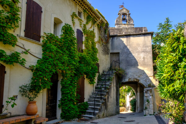 Rue de Rasteau avec passage sous clocher en pierre.