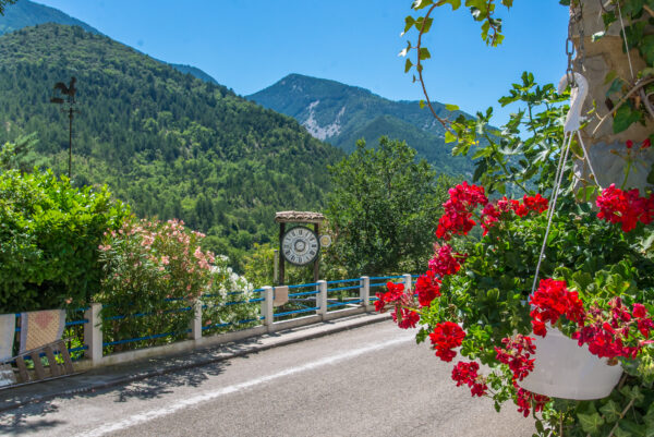 Paysage à l'entrée de Saint-Léger-du-Ventoux avec grosse horloge installée en bord de route.