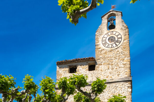 Vue sur le clocher de l'église de Villedieu avec son horloge.