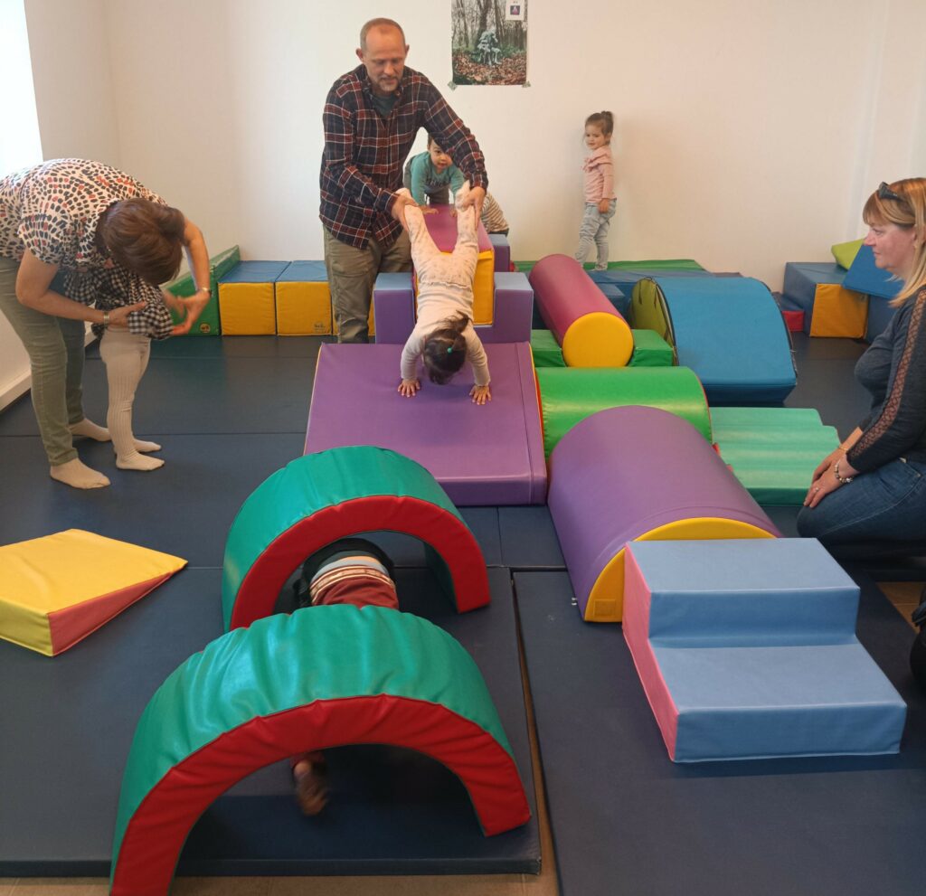 Des enfants participent à un atelier de motricité sur des tapis adaptés.