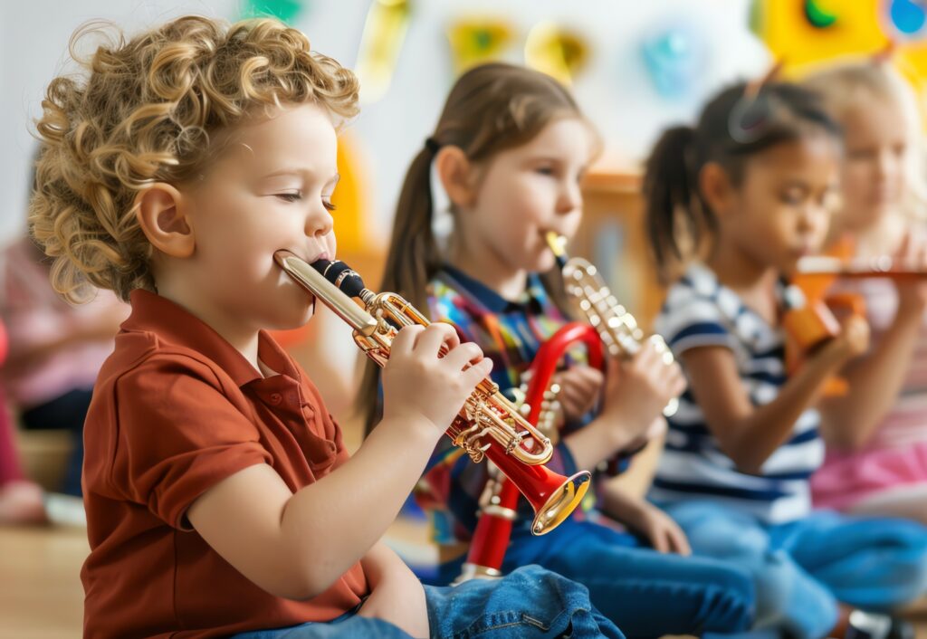 Des jeunes enfants s'initient à la trompette lors d'un atelier de découverte des instruments.