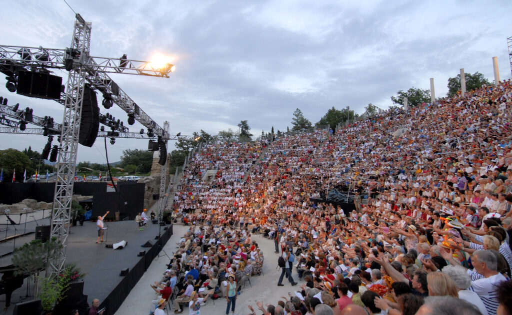 Vue sur le public installé dans les gradins du théâtre antique de Vaison-la-Romaine lors d'un spectacle.