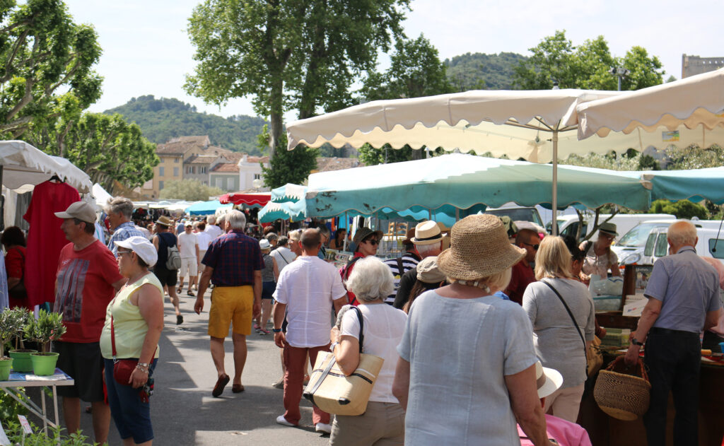 Des personnes déambulent dans les rues de Vaison-la-Romaine lors du marché provençal.