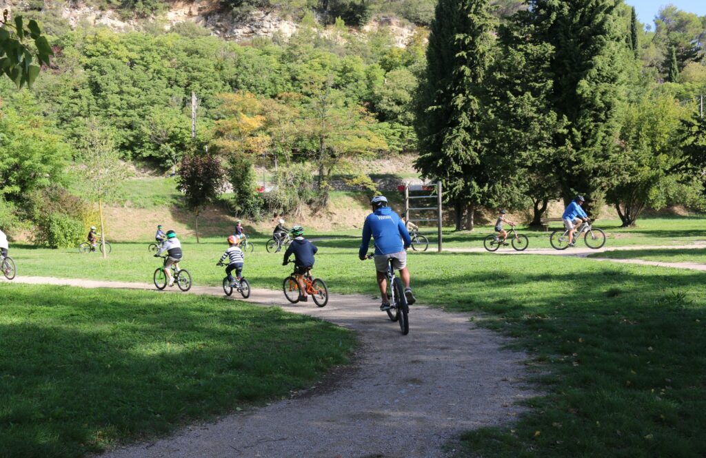 Des enfants faisant du vélo accompagnés par un adulte.