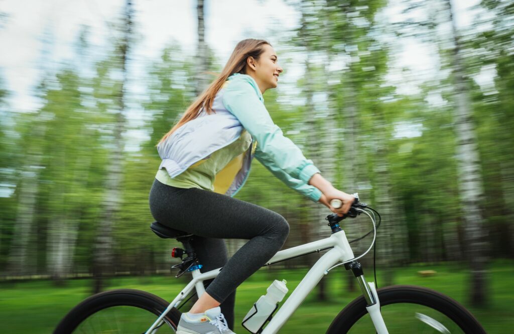 Une femme souriante en train de faire du vélo.